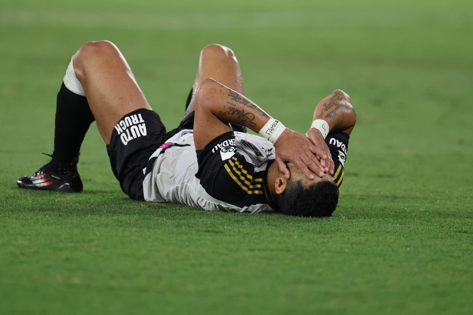 Hulk leva mãos ao rosto deitado no gramado durante partida do Brasileirão; jogador está fora de Atlético-MG x Flamengo