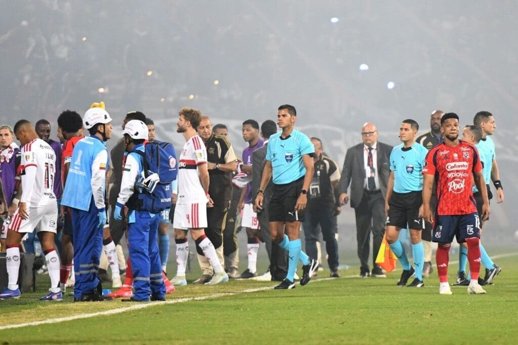 Jogadores do Flamengo em campo enquanto aguardam definição da confusão em Medellín