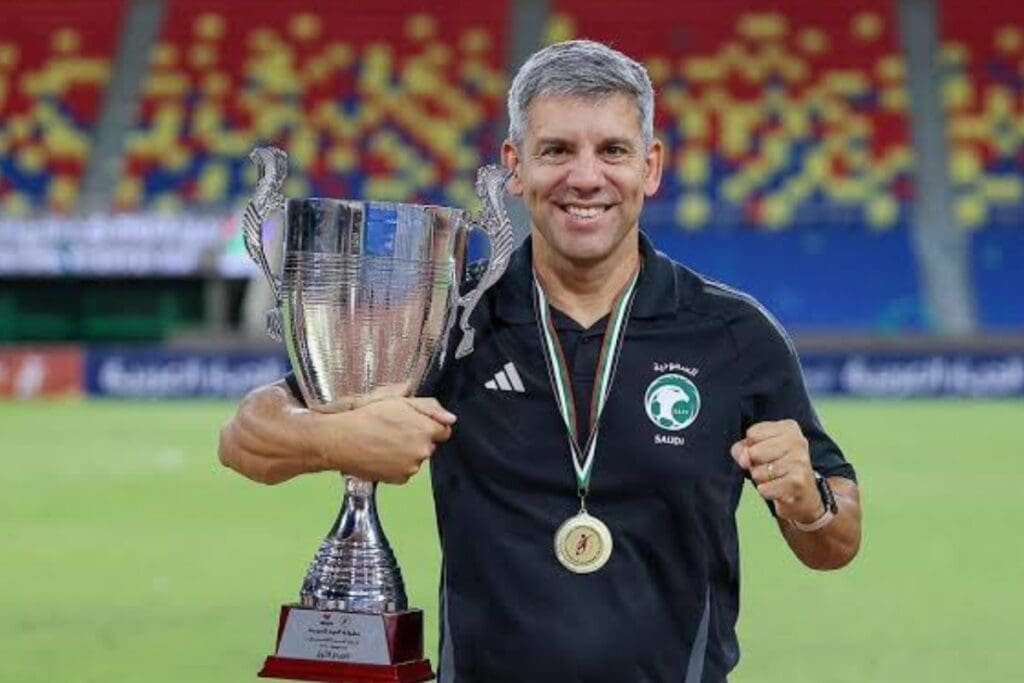 Técnico Marcos Soares segurando taça conquistada com a Arábia Saudita