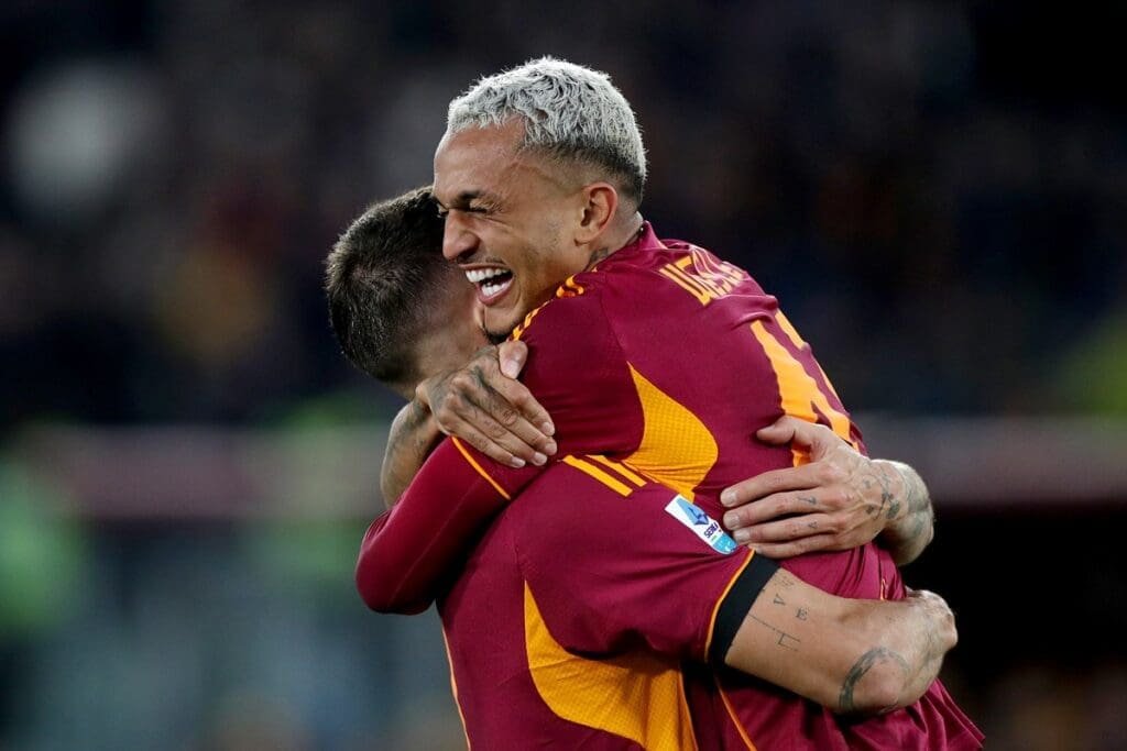 Wesley abraça companheiro sorridente após marcar gol pela Roma
