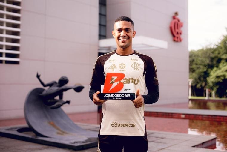 Samuel Lino sorri e exibe prêmio de melhor jogador do Flamengo em maio