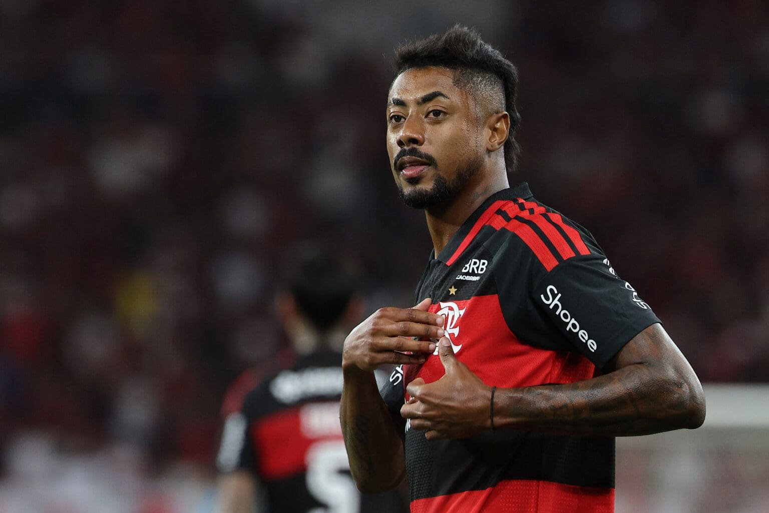 Bruno Henrique comemora gol pelo Flamengo apontando para o escudo