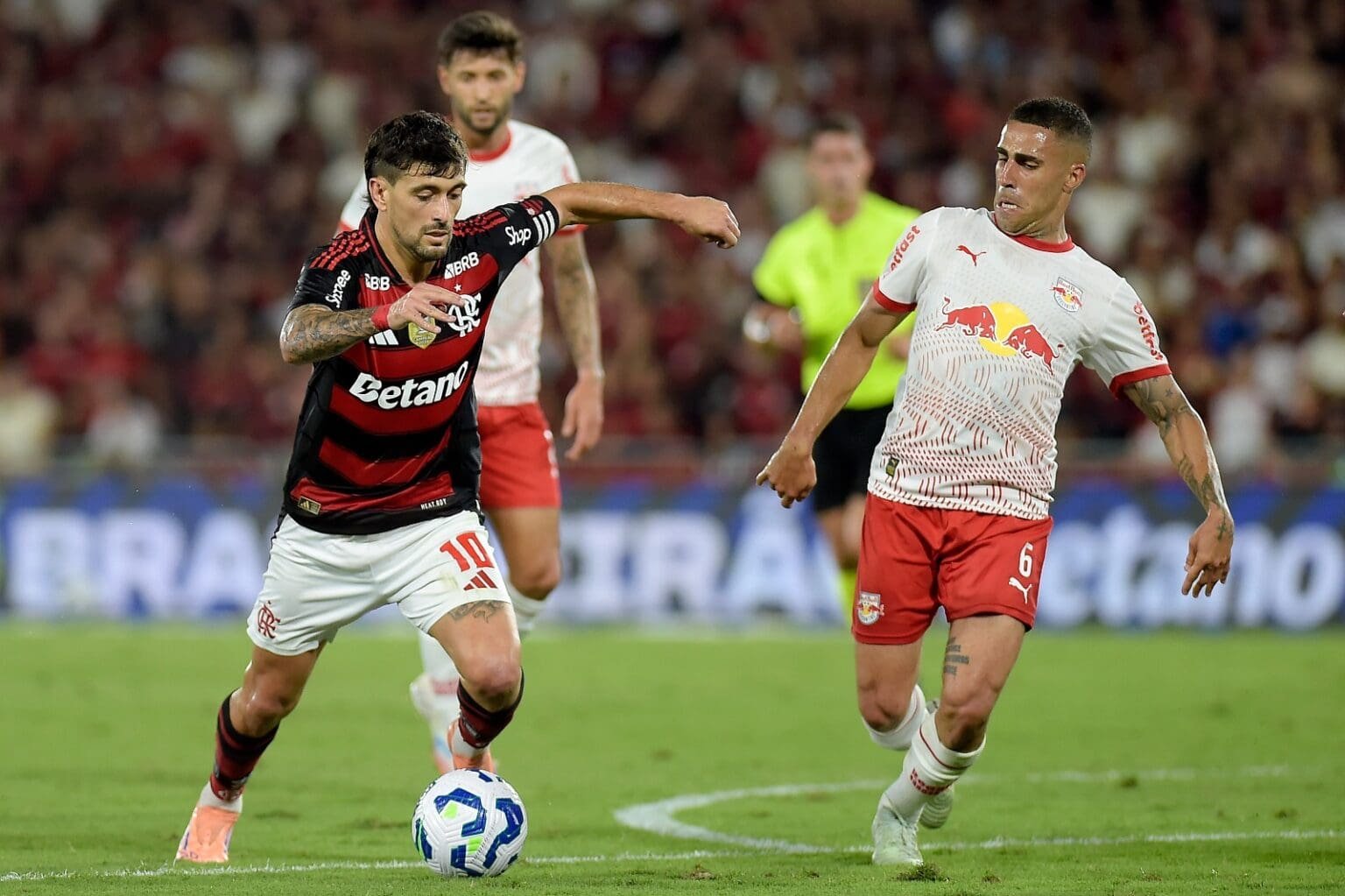 Arrascaeta conduz a bola enquanto é marcado por Gabriel em Flamengo x Bragantino