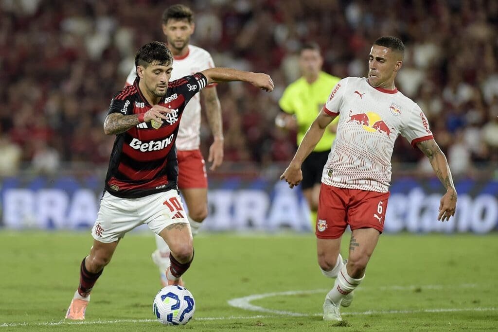 Onde assistir Flamengo x Bragantino pelo Brasileirão ao vivo: horário e canais Arrascaeta arma finalização enquanto Gabriel tenta bloquear durante Flamengo x Bragantino pelo Brasileirão 2025