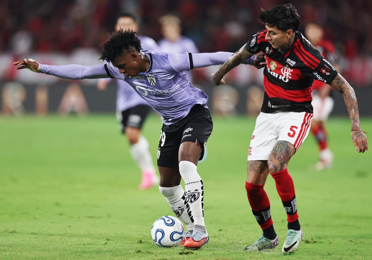 Pulgar divide a bola com atacante rival durante Flamengo x Del Valle
