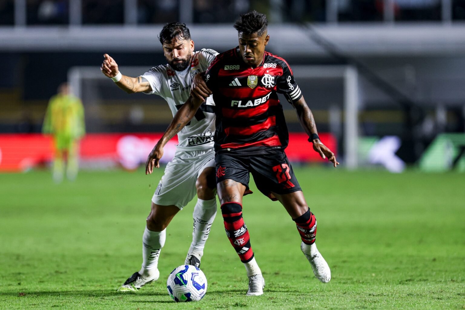 Onde assistir Santos x Flamengo ao vivo hoje: horário, canais e guia do jogo Bruno Henrique disputa a bola com Luan Peres na Vila Belmiro; saiba onde assistir Santos x Flamengo