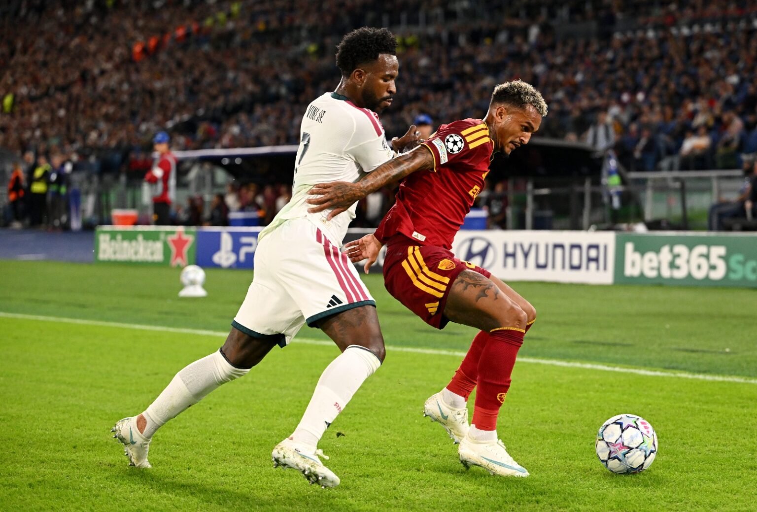 Wesley protege a bola contra a marcação de Vini Jr durante Roma x Real Madrid pela Champions League